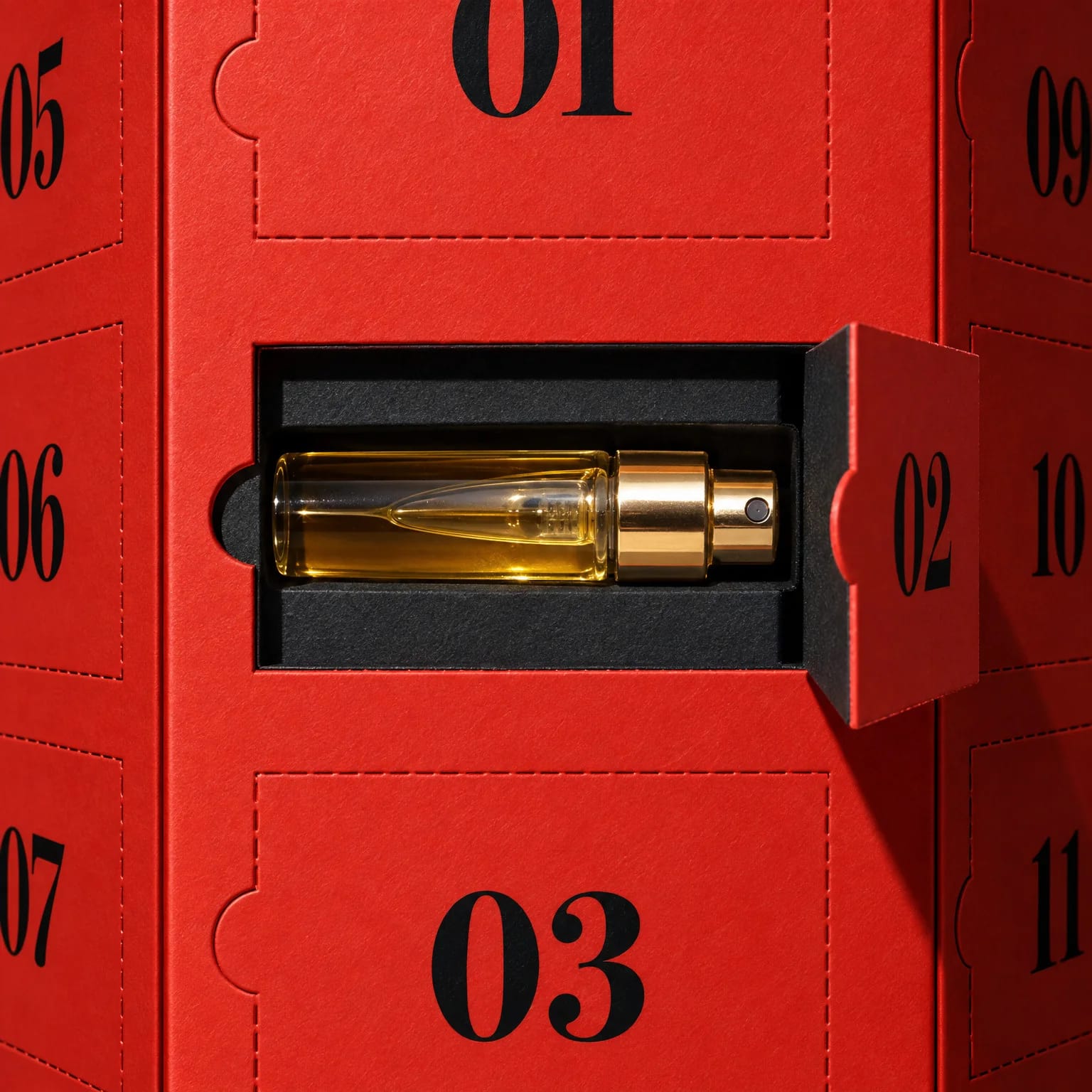Puerta 02 abierta en la caja roja, con un vial de perfume con tapón dorado en una ranura negra de cartón
