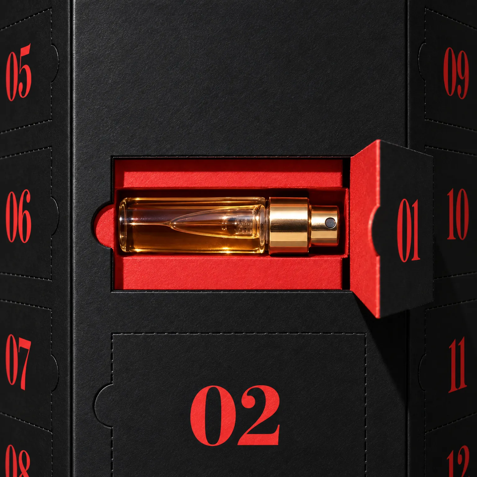 Puerta 01 abierta en la caja negra, con un vial de perfume con tapón dorado en una ranura roja de cartón