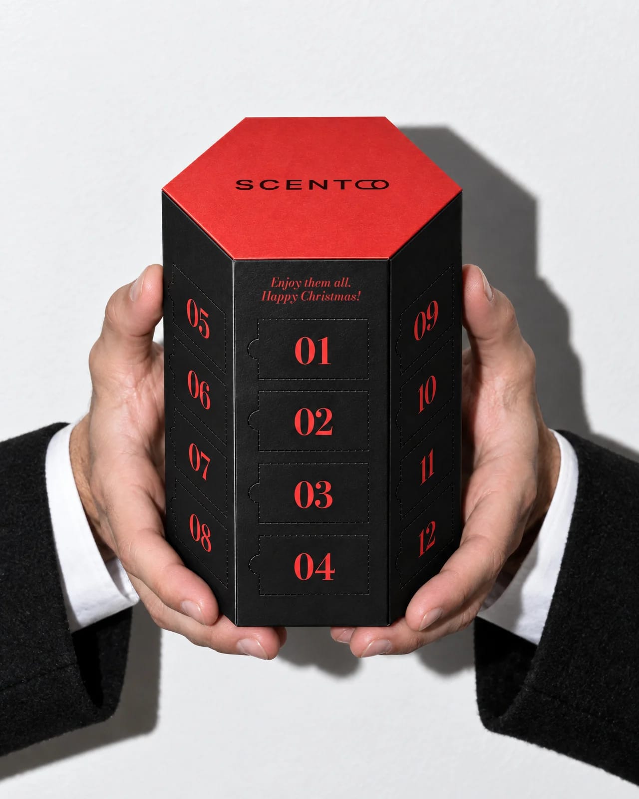 Unas manos con puños de camisa blanca ofrecen el calendario negro para él, con los números de las puertas en rojo