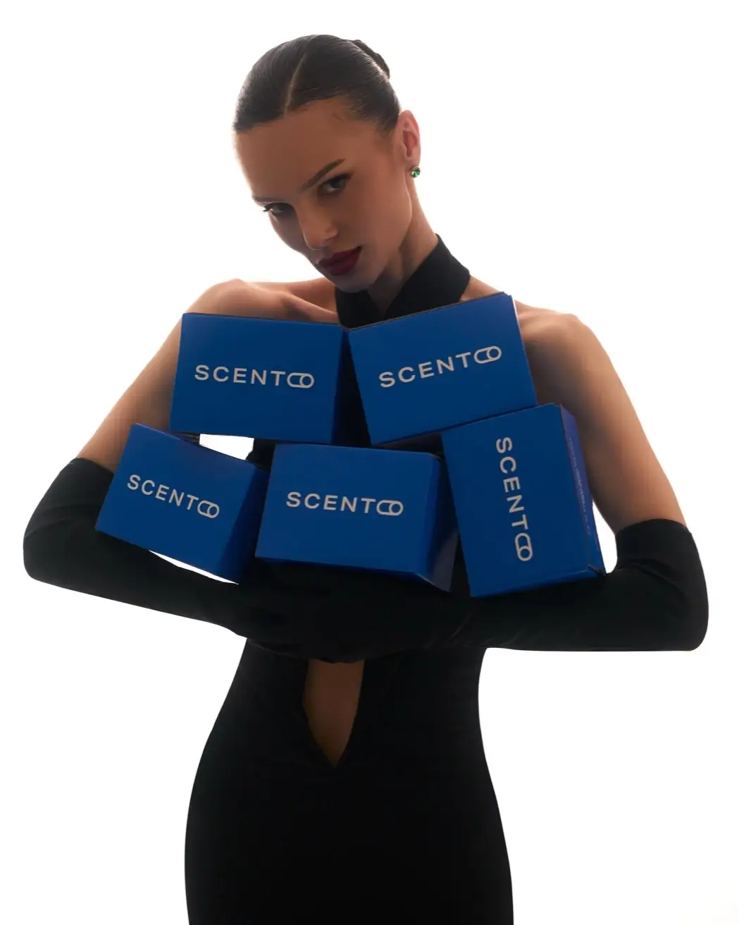 Eine Frau hält Scento-Versandboxen vor weißem Hintergrund